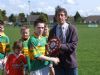 The Creggan Captain receives the Feile trophy from Leo Heatley. Creggam's name is the only one on the shield, 5-in-a-row!